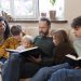 Miembros de la familia leyendo la Biblia juntos, fortaleciendo su fe y vínculo familiar.
